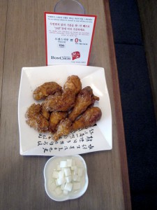 After being double fried, Bon Chon chicken is served with pickled Korean radish.