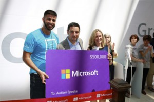 Autism Speaks Executive Vice President Lisa Goring accepts a donation at the ribbon-cutting for the new Microsoft retail store in Garden City