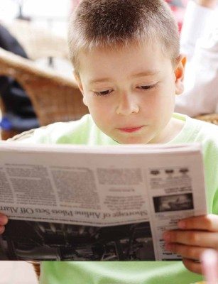 Boy reading newspaper