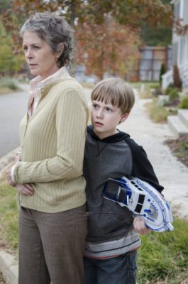 Sam Anderson (played by Major Dodson) seeking protection from Carol (Melissa McBride) (Photo Credit: Gene Page/AMC)